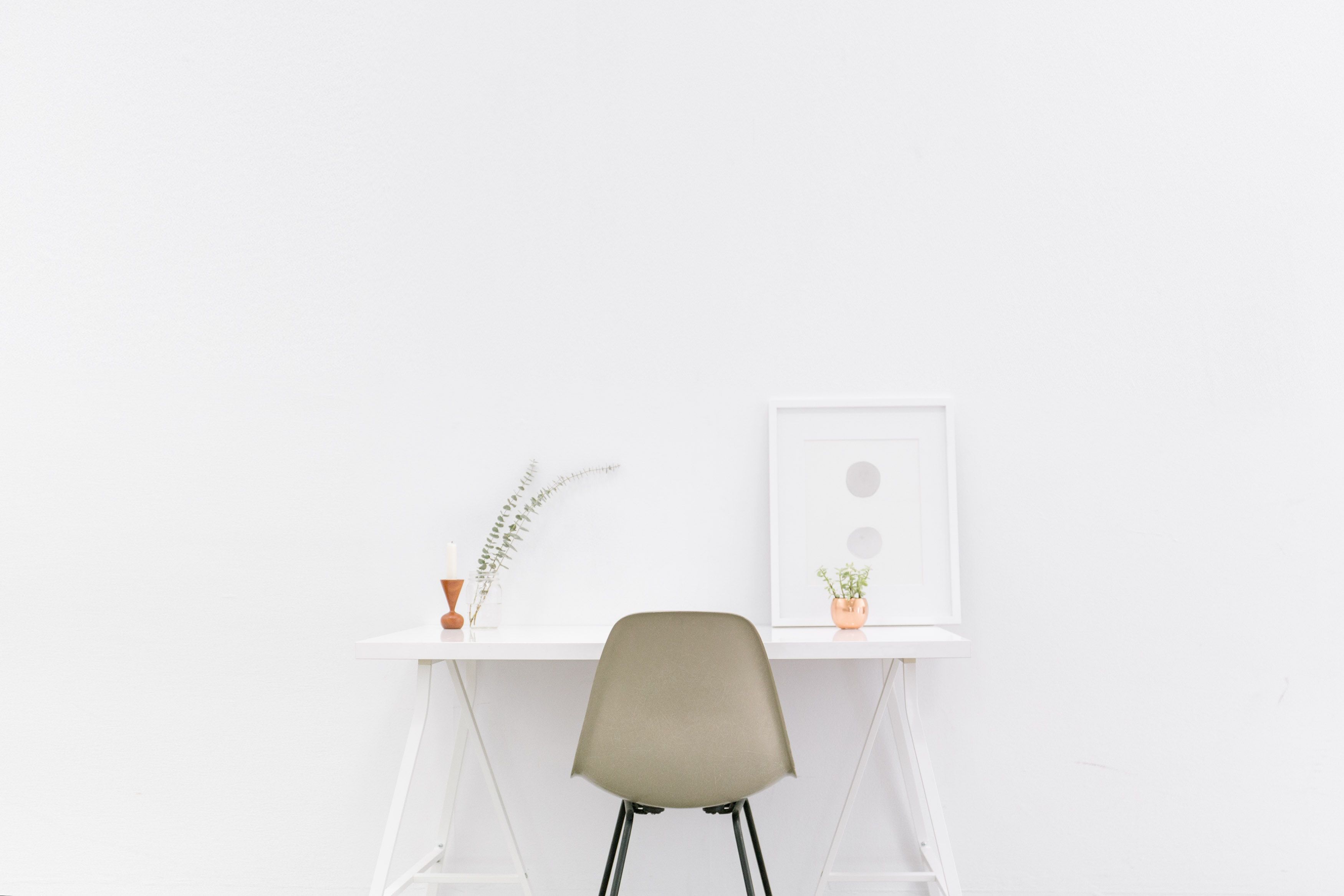 a chair white chair at a white desk on a white wall